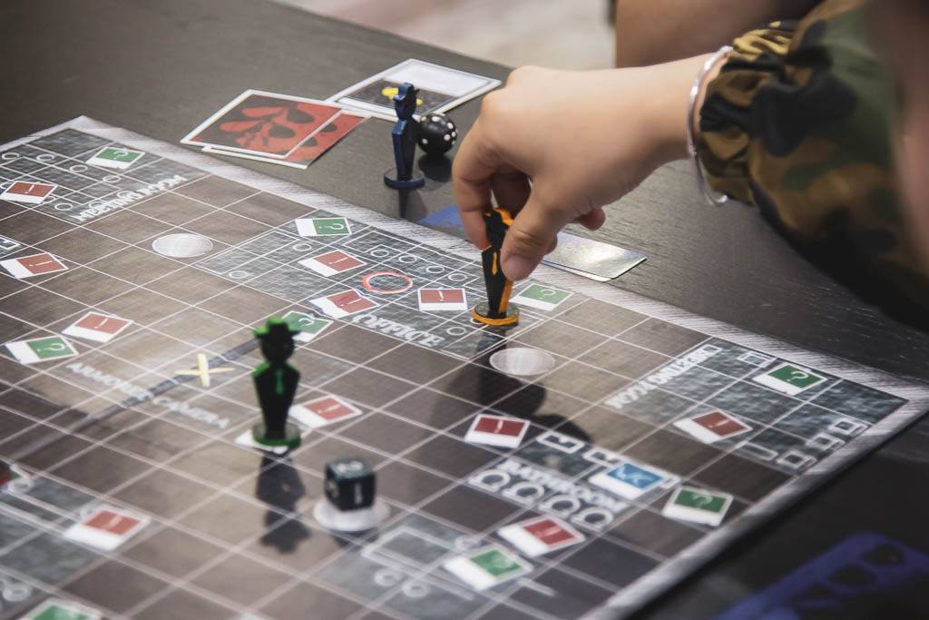 Una persona está jugando a un juego de mesa y mueve una de las piezas sobre el tablero.