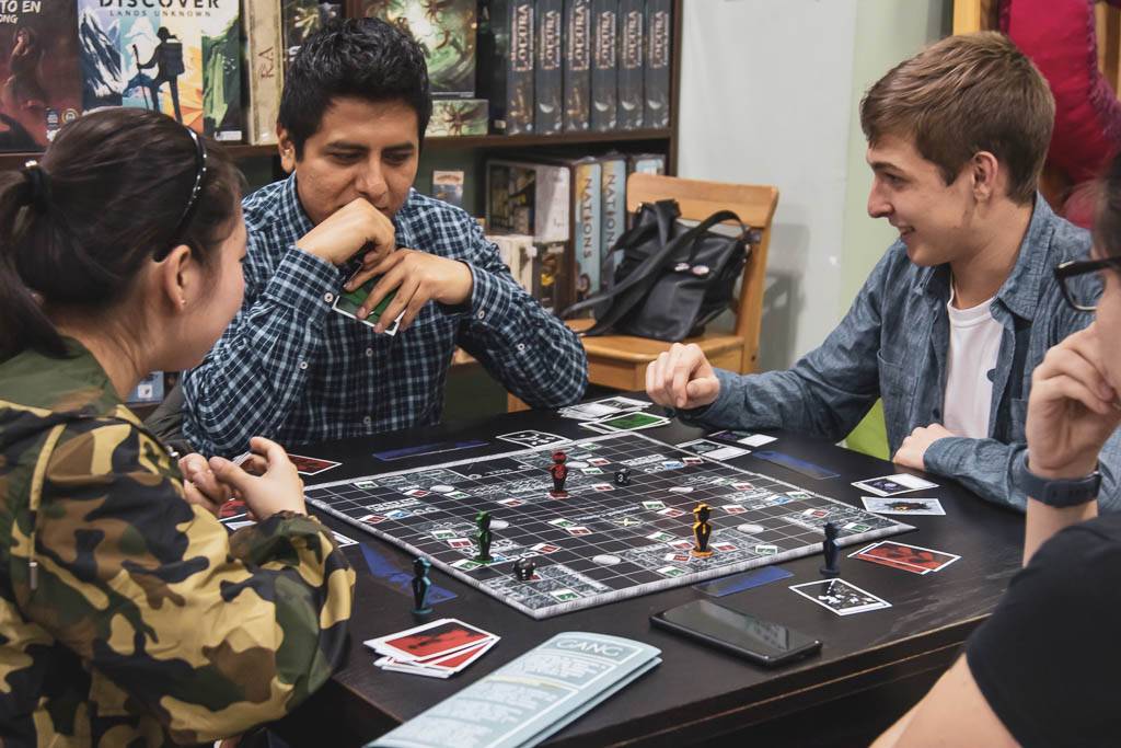Un grupo de amigos juega a un juego de mesa en una tienda de juegos.
