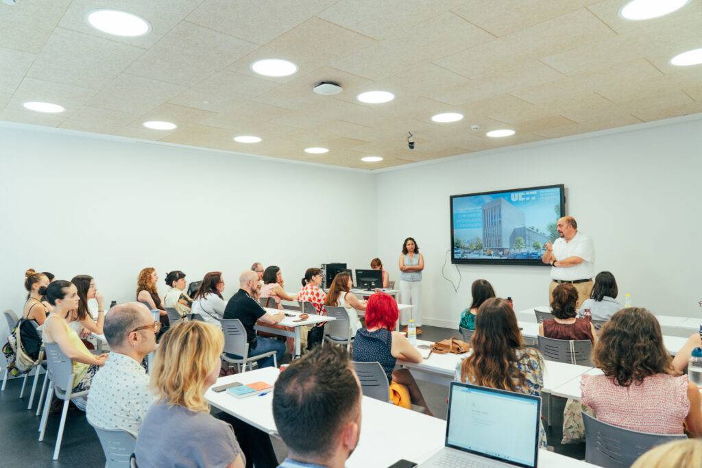 Un grupo de personas asiste a una presentación en una sala moderna y luminosa.