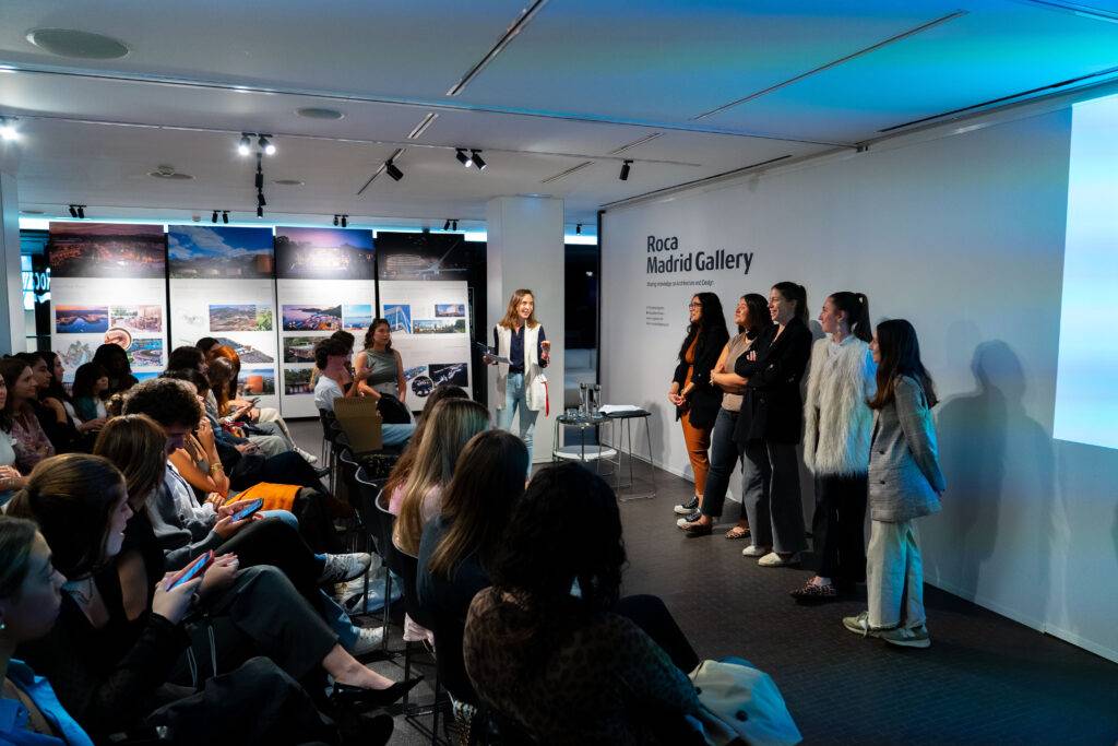 Una presentación en la Galería Roca de Madrid con varios asistentes y ponentes en el escenario.