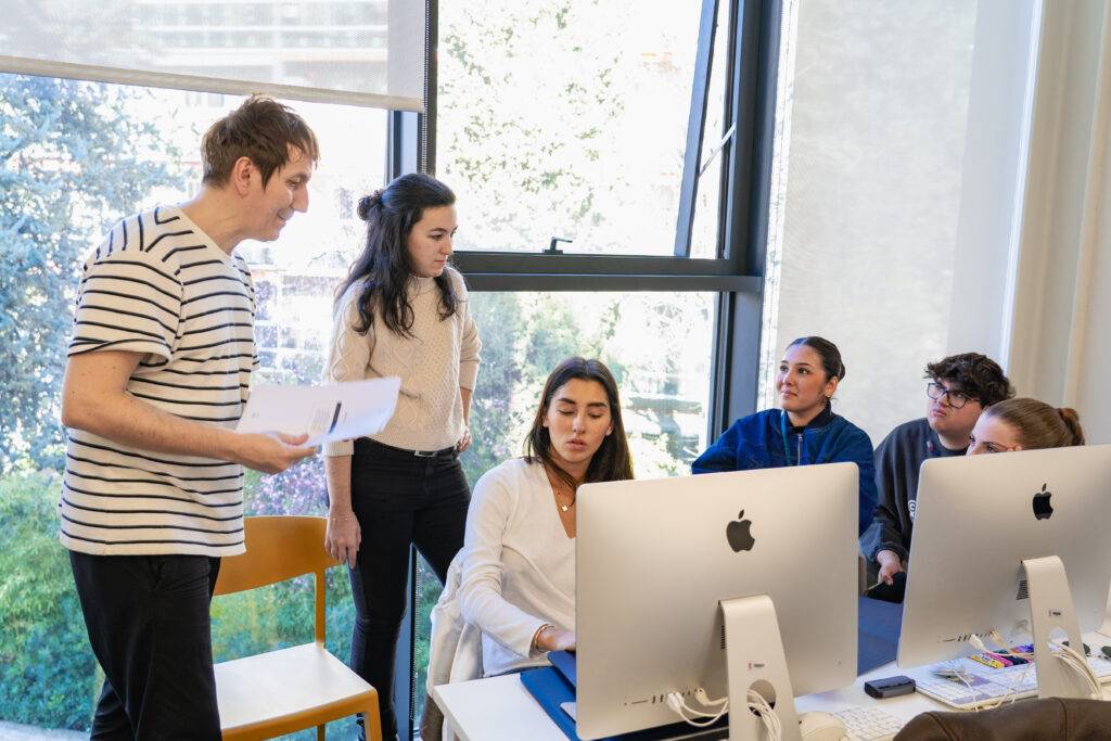 Un grupo de personas colaborando en un entorno de trabajo moderno frente a computadoras.