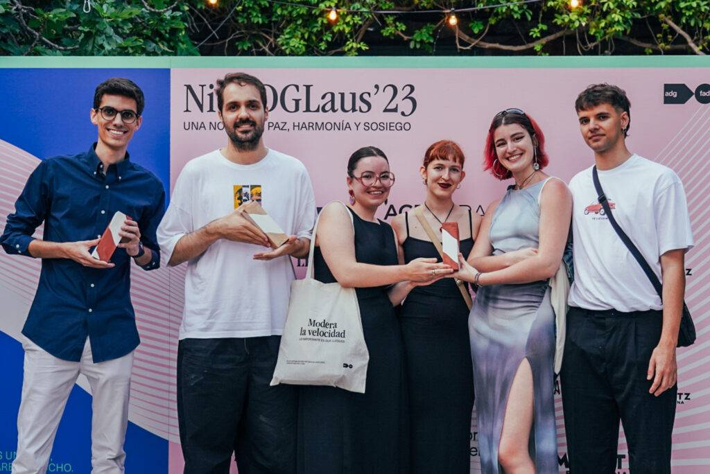 Un grupo de seis personas celebra un evento, sosteniendo premios en un ambiente festivo al aire libre.