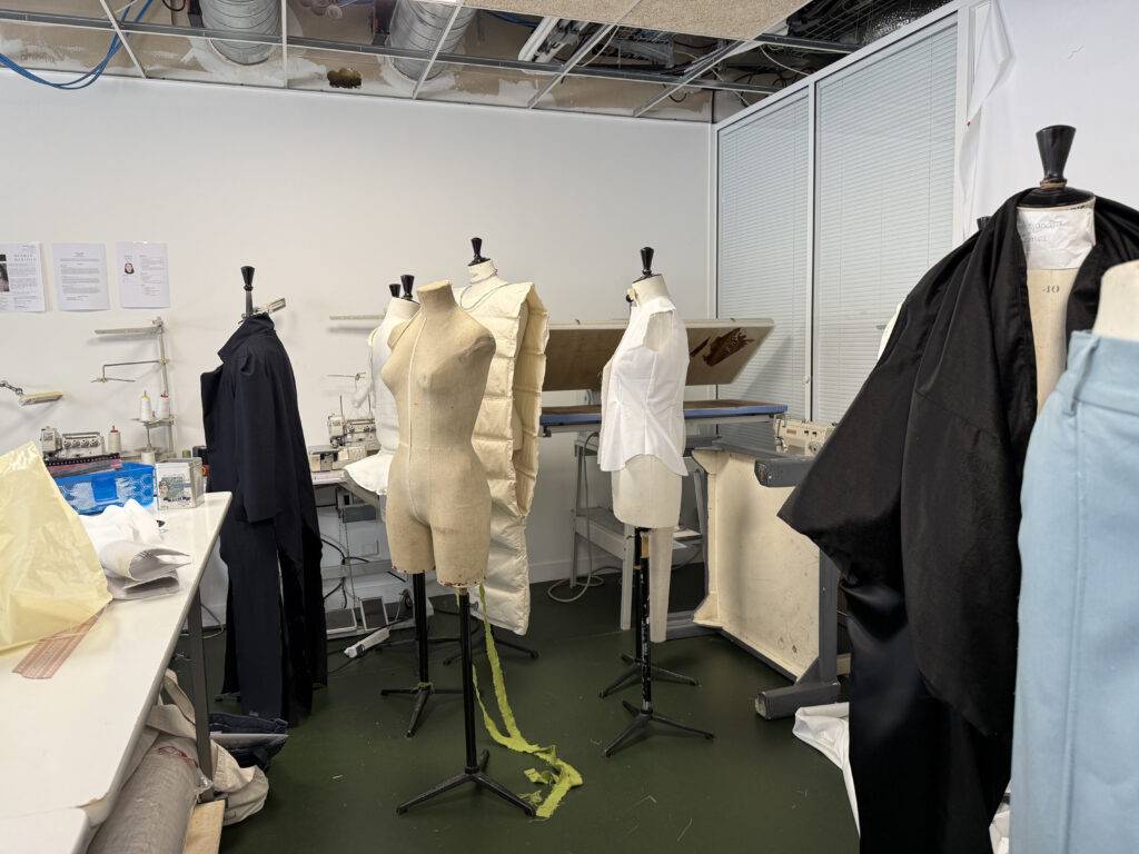 La imagen muestra un taller de moda con varios maniquíes en un entorno de trabajo.