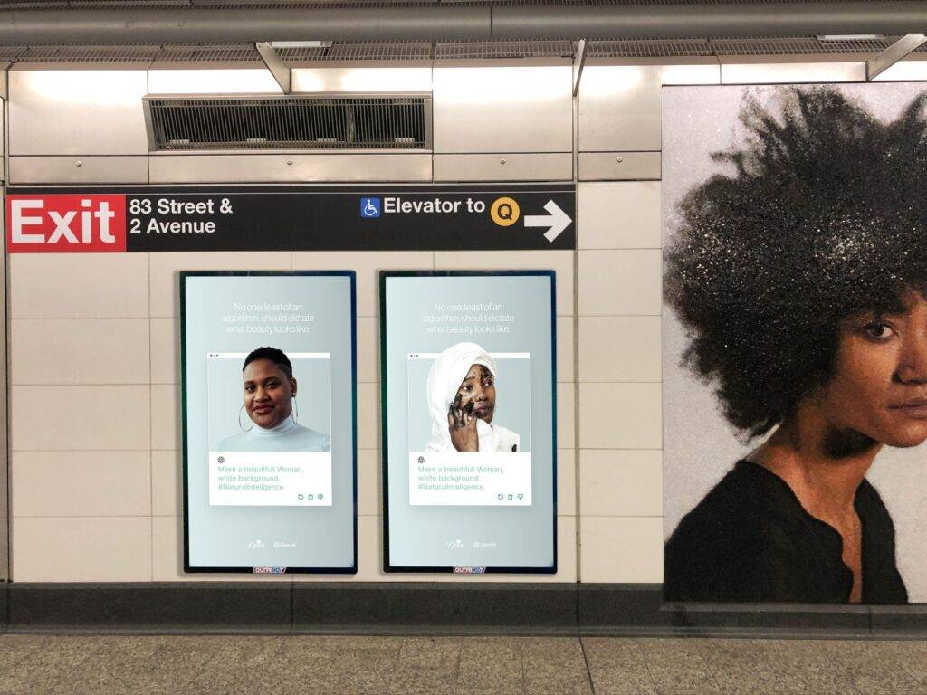 La imagen muestra dos anuncios en una estación de metro junto a una obra de arte que representa a una persona con peinado rizado.