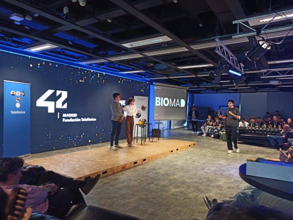 Una presentación en un auditorio con participantes y un fondo decorado por la Fundación Telefónica.