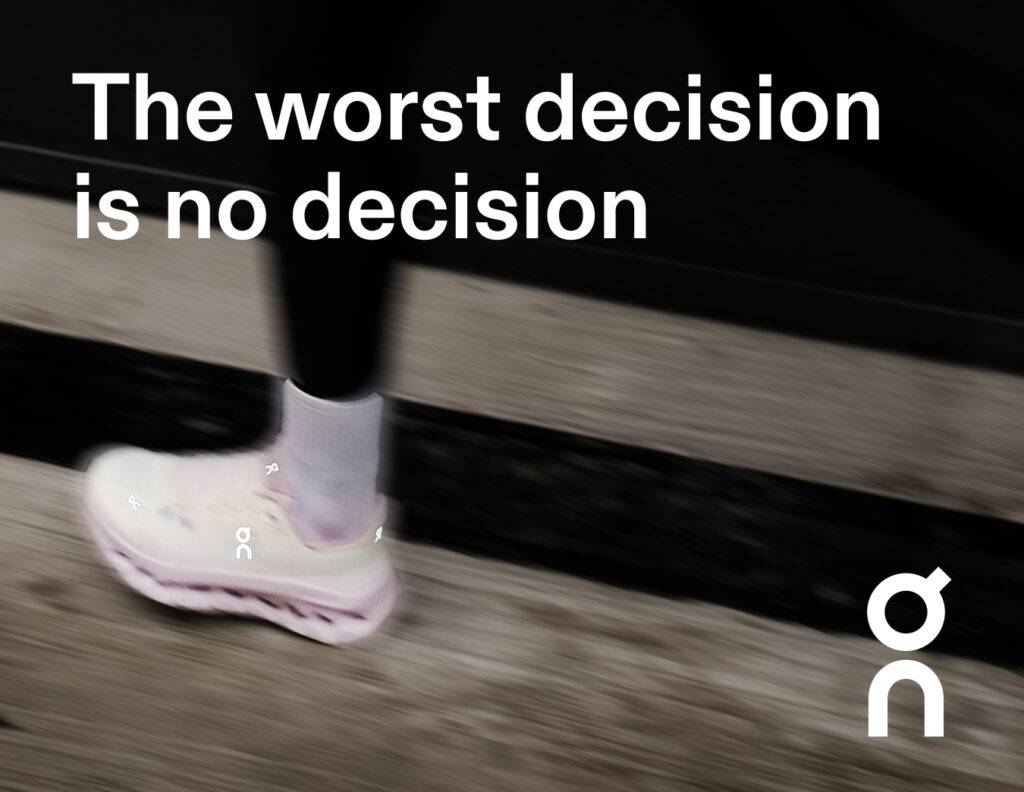 Una persona camina usando zapatillas deportivas de color claro sobre una superficie gris.