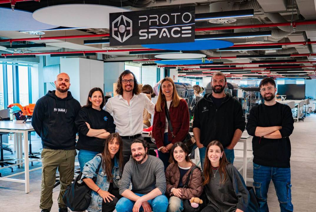 Un grupo de personas posando en un espacio de trabajo llamado Proto Space.