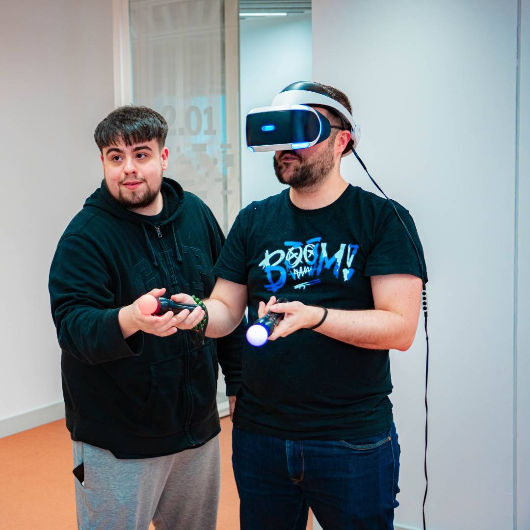 Dos personas interactuando con un sistema de realidad virtual en un entorno moderno.