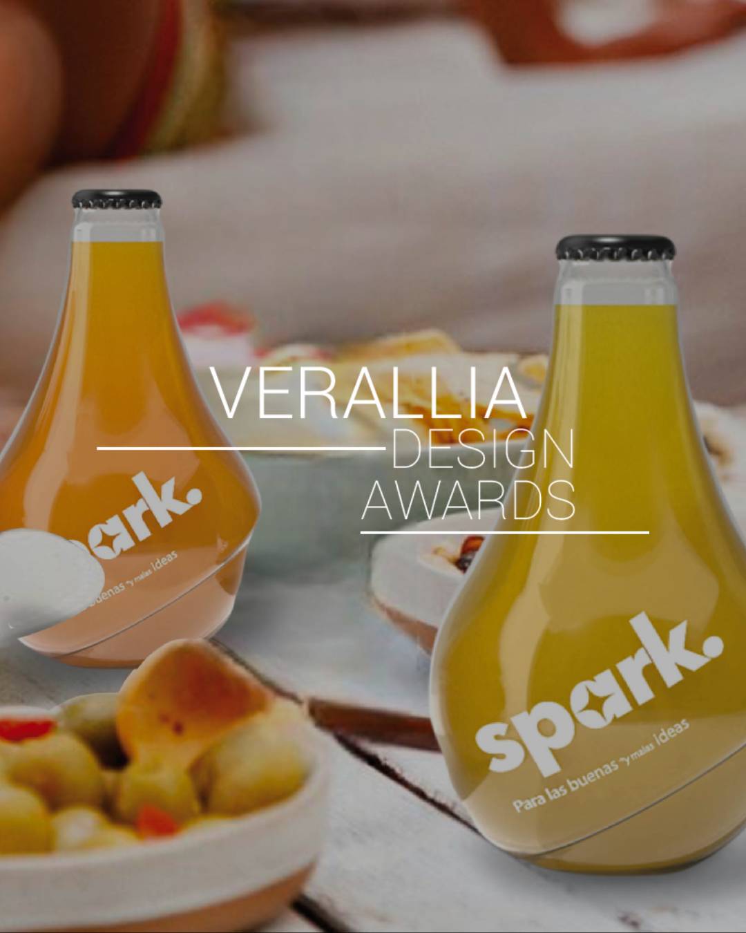 Botellas de bebida con diseño moderno sobre una mesa con alimentos.