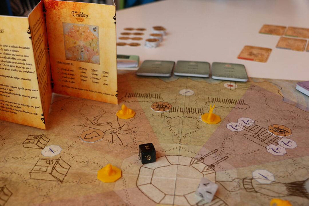 Una imagen de un juego de mesa con un tablero, fichas y cartas.