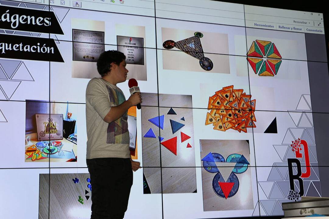 Un presentador expone imágenes de diversas figuras geométricas y colores en una pantalla grande.