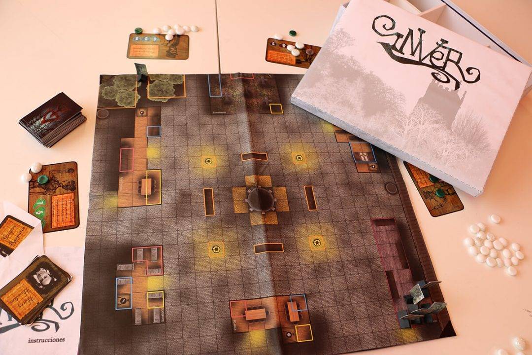 Un juego de mesa está preparado sobre una mesa con un tablero detallado, tarjetas y piezas de juego.