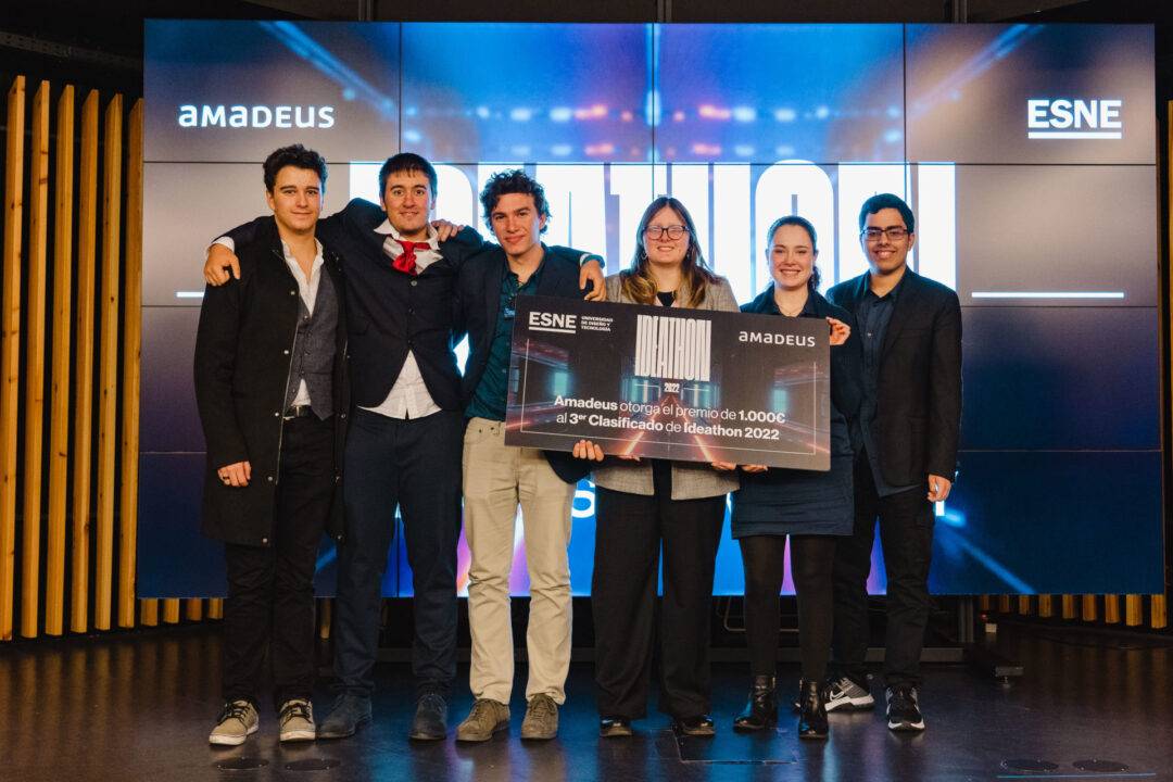 Un grupo de seis personas sonrientes sostiene un premio durante un evento en ESNE.