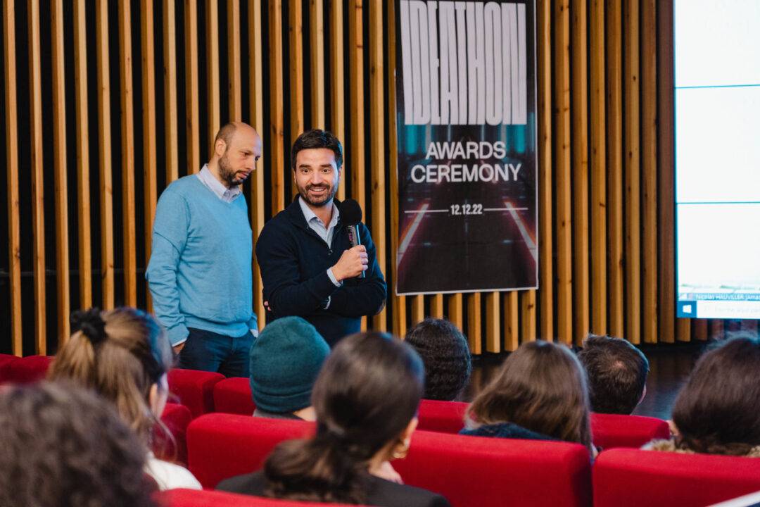 Un orador presenta en un evento frente a una audiencia en un auditorio.