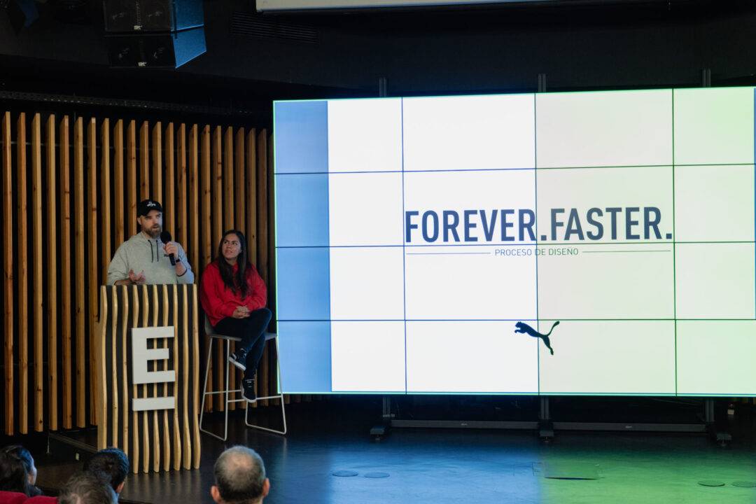 Una presentación sobre diseño con dos expositores en un escenario.