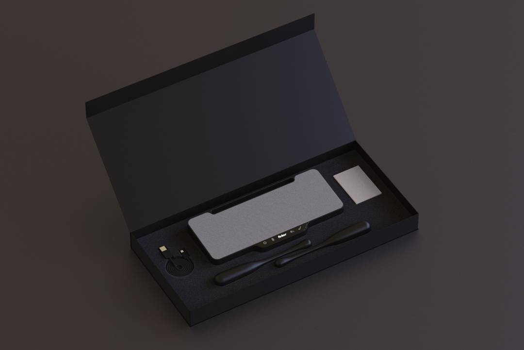 Un estuche negro abierto que contiene un dispositivo rectangular, una tarjeta y dos instrumentos delgados.