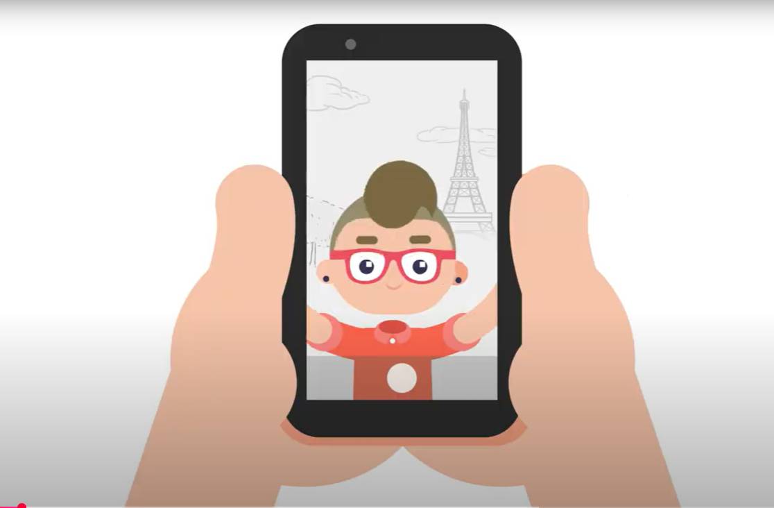 Un personaje animado sonríe mientras se toma una selfie con un fondo de la Torre Eiffel.
