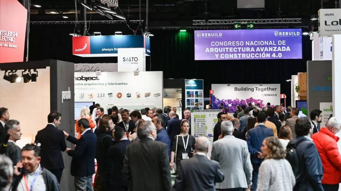 La imagen muestra un evento con muchas personas en un congreso sobre arquitectura y construcción avanzada.