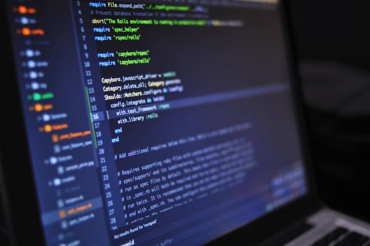 Una computadora portátil muestra líneas de código en la pantalla.
