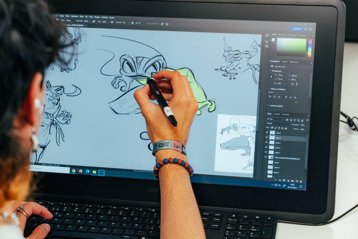 Una persona dibujando en una tableta gráfica mientras trabaja en un diseño digital.