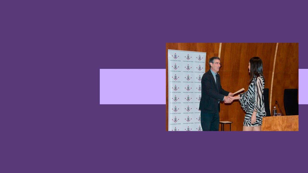 Un evento donde dos personas se dan la mano y una de ellas sostiene un libro.