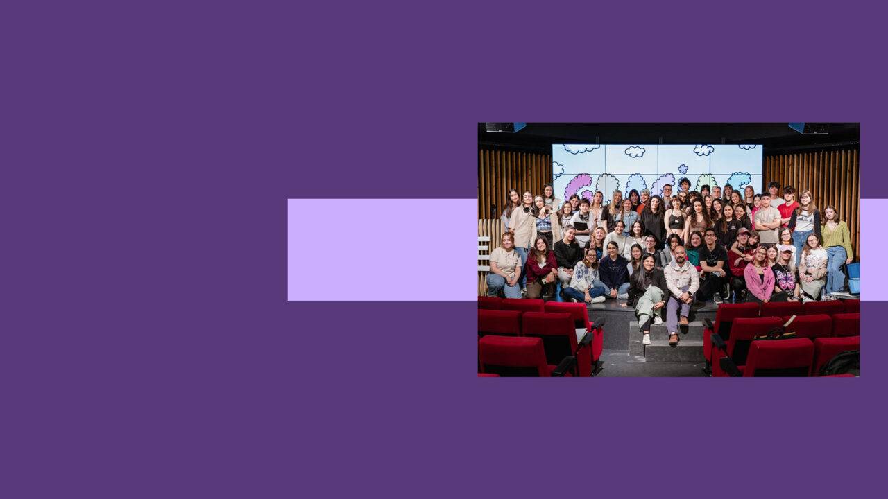 Un grupo diverso de personas posando juntas en un escenario con un fondo colorido.