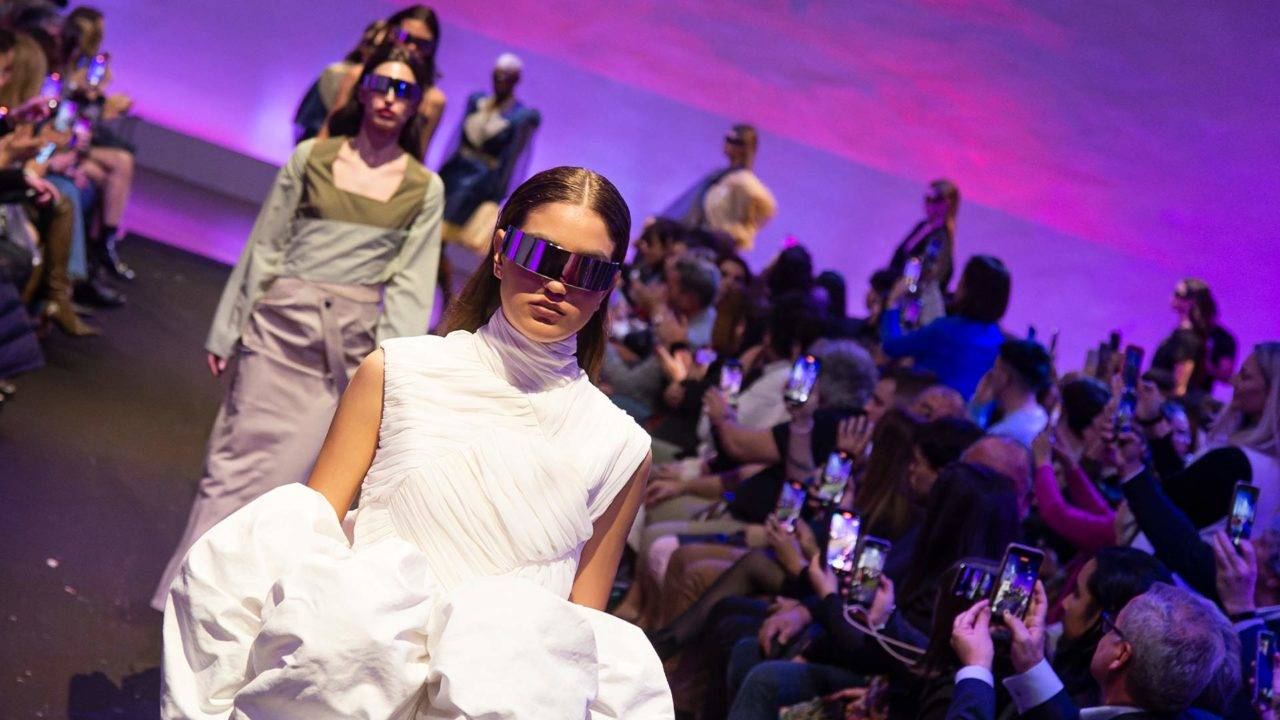 Un desfile de moda con modelos vistiendo atuendos contemporáneos y accesorios llamativos.