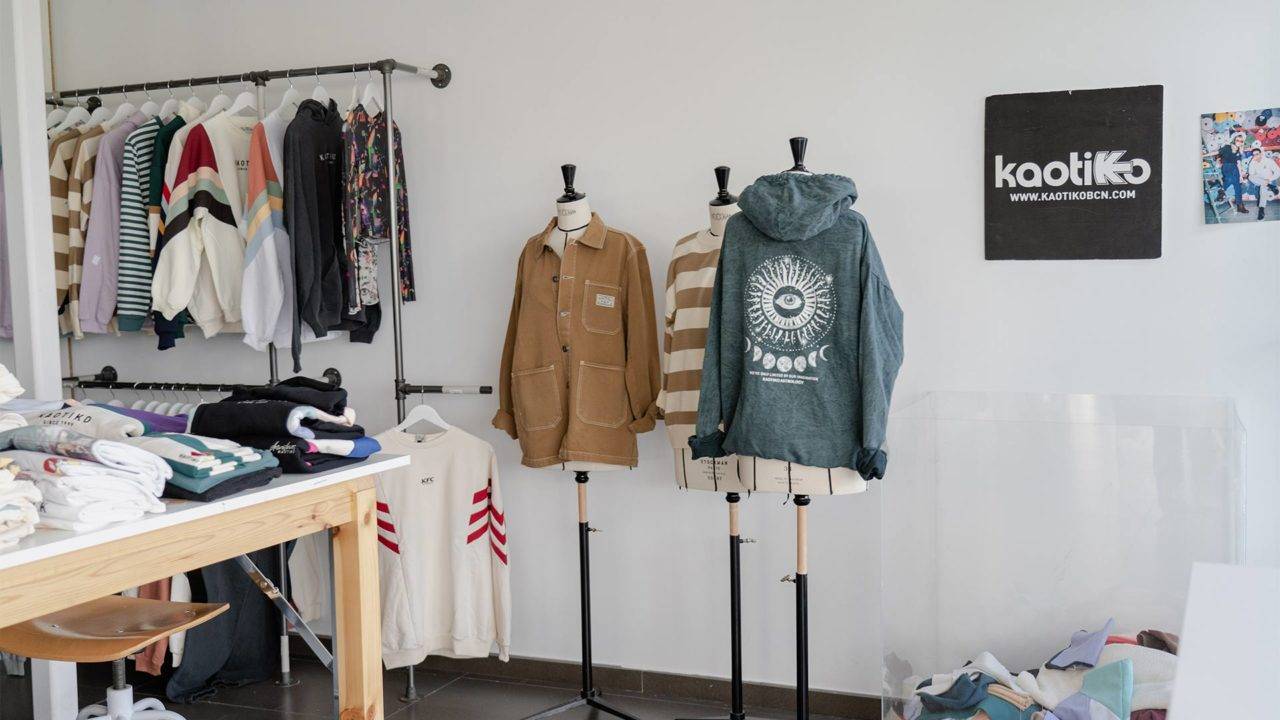 Una tienda de ropa con prendas exhibidas en percheros y maniquíes.