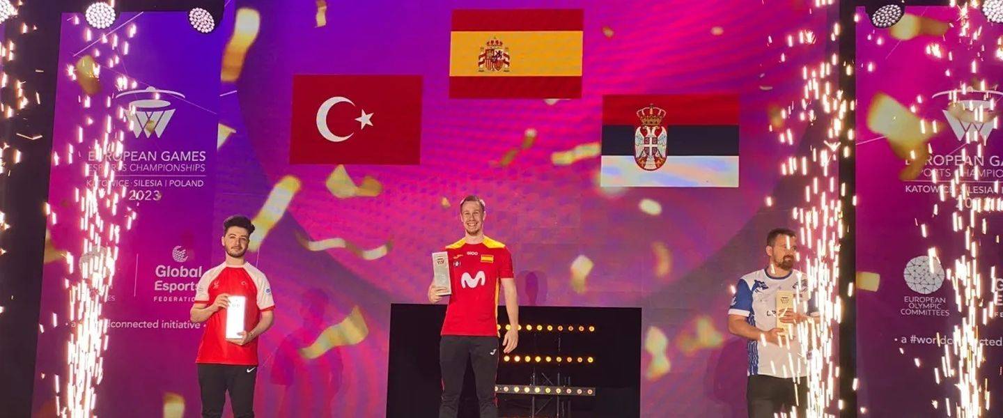 Tres competidores en el podio con banderas de Turquía, España y Serbia de fondo.