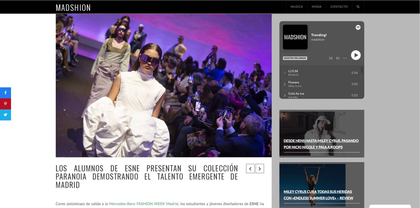 Una pasarela de moda donde los estudiantes presentan una colección innovadora en un ambiente vibrante.