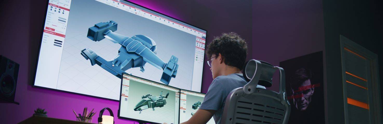 Un joven trabaja en el diseño de un modelo 3D de una nave espacial en un entorno digital.