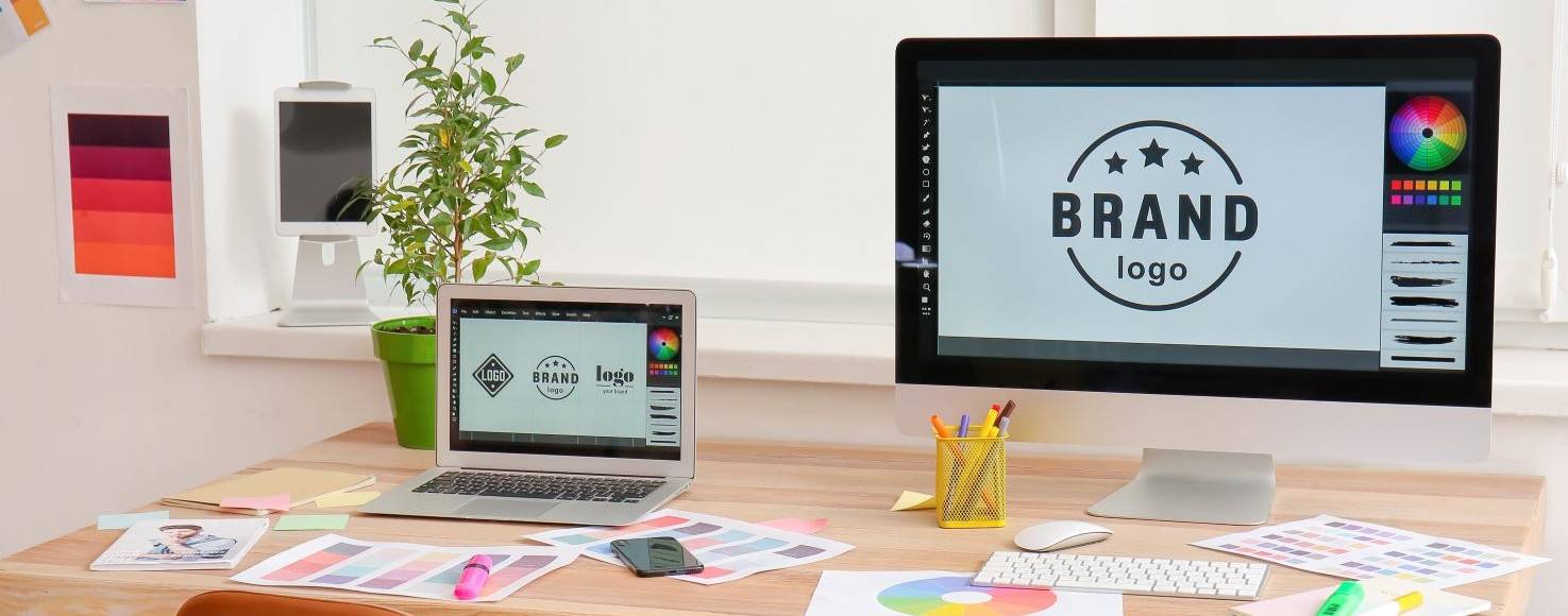 Una oficina de diseño con computadoras y materiales creativos para branding.
