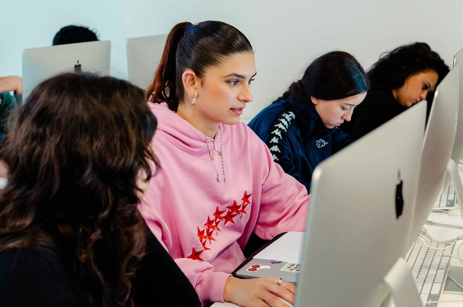 Un grupo de estudiantes concentrados en sus computadoras trabajando en un proyecto.