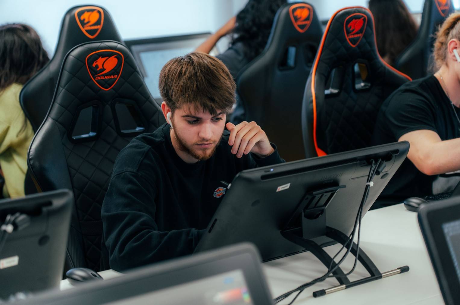 Un joven está trabajando en una tableta gráfica en un entorno de estudio moderno.