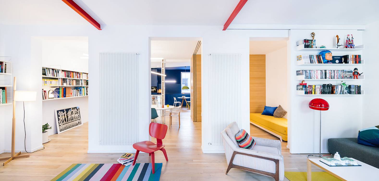 Un moderno salón con estanterías llenas de libros y una decoración colorida.