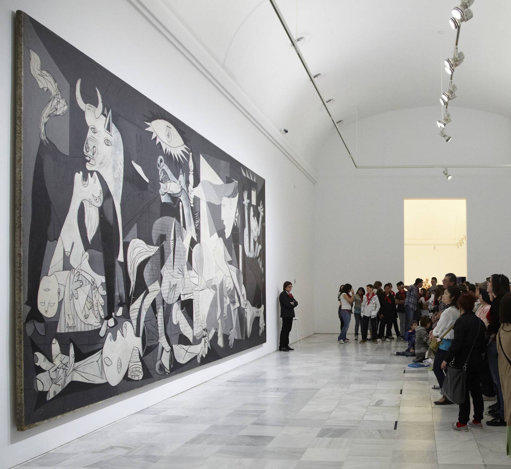 Una multitud observa una gran obra de arte en un museo.