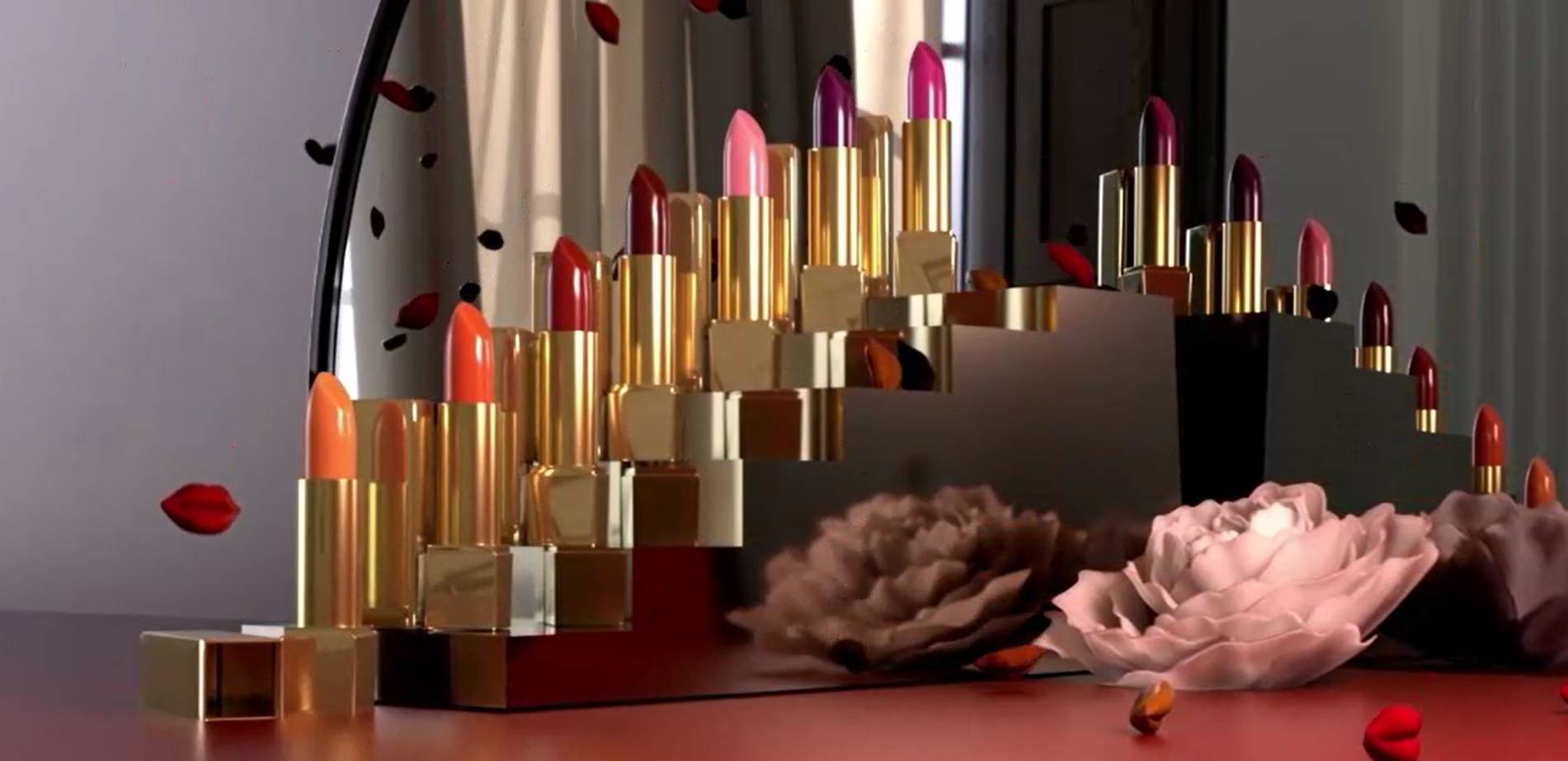 Una colección de labiales en tonos variados dispuestos elegantemente frente a un espejo con pétalos de flores alrededor.