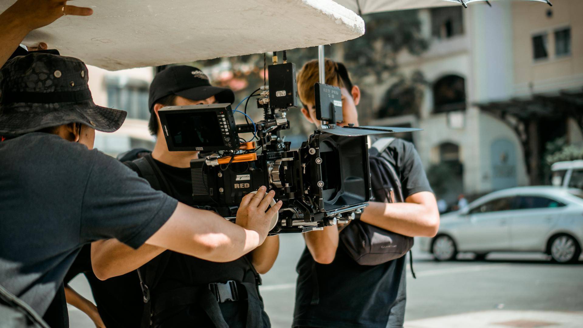 Un grupo de personas está operando una cámara de cine en una calle.