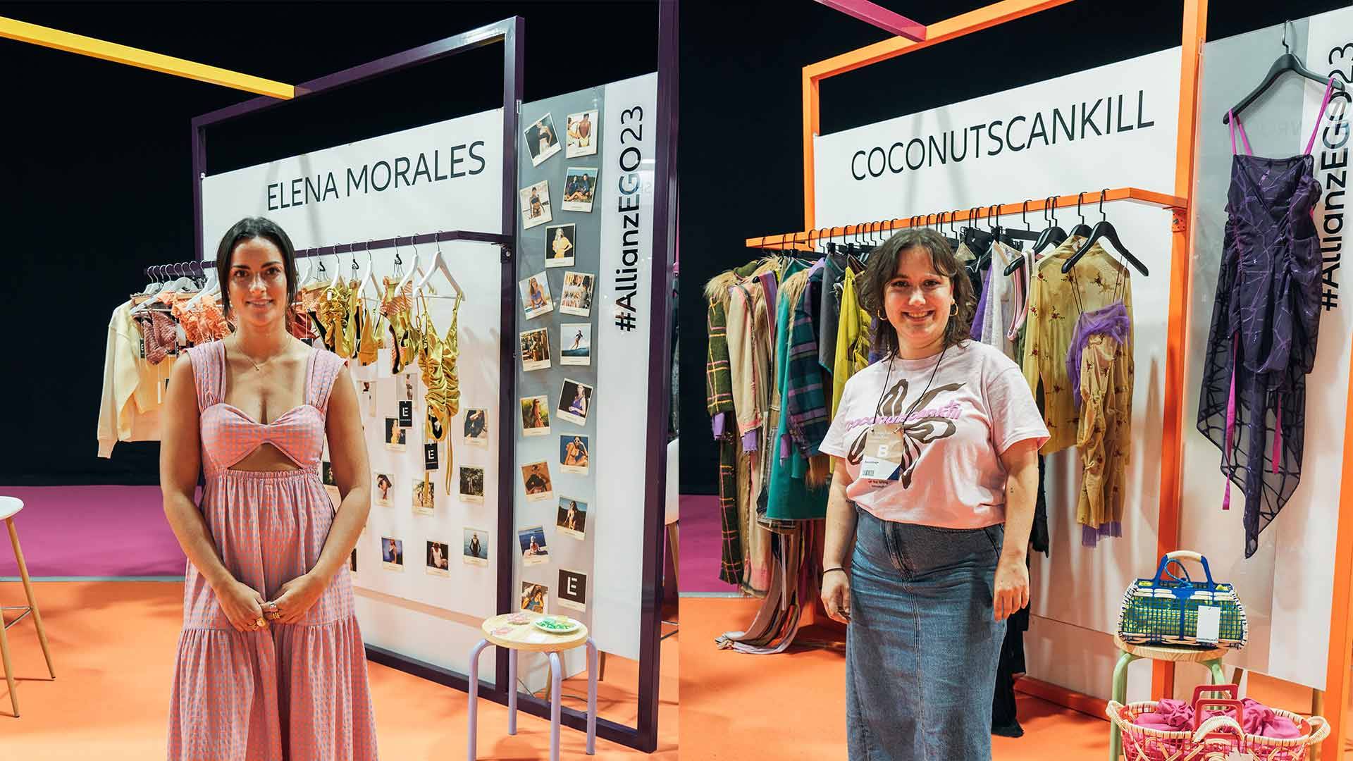 La imagen muestra a dos mujeres posando en un evento de moda con ropa y accesorios exhibidos en sus stands.