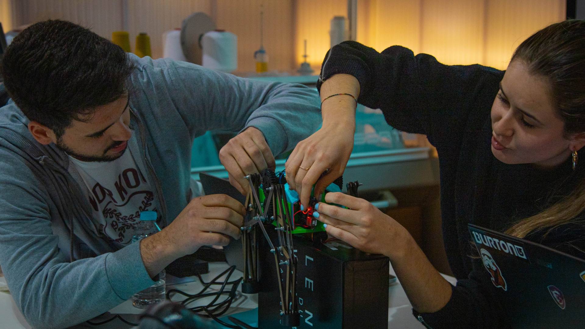 Dos personas trabajan juntas en un proyecto de robótica.