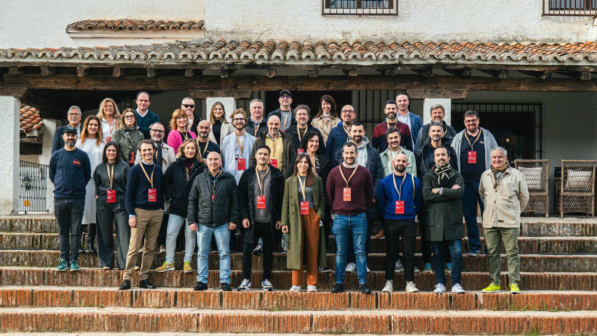 Un grupo de personas posando en escaleras frente a un edificio.