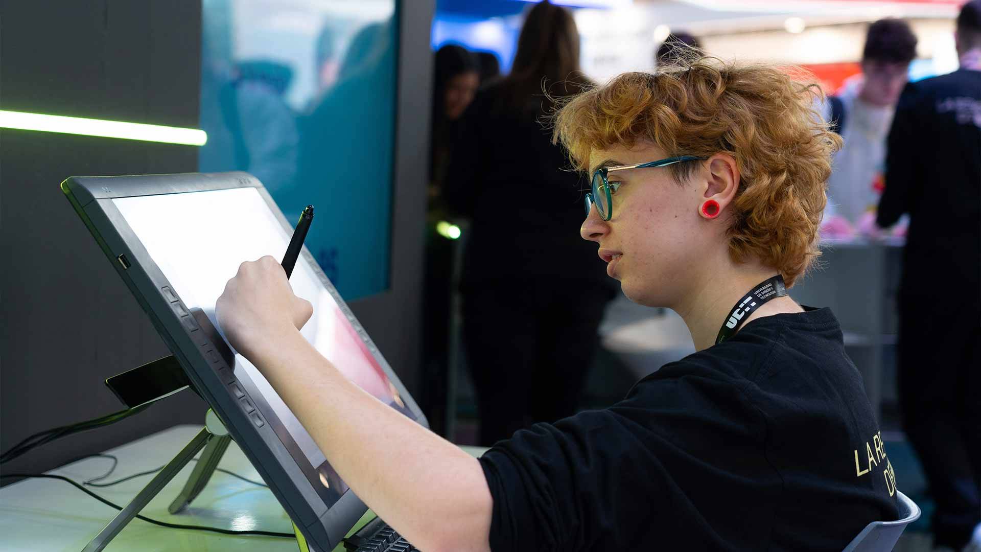 Una persona con cabello rizado está dibujando en una tableta digital.