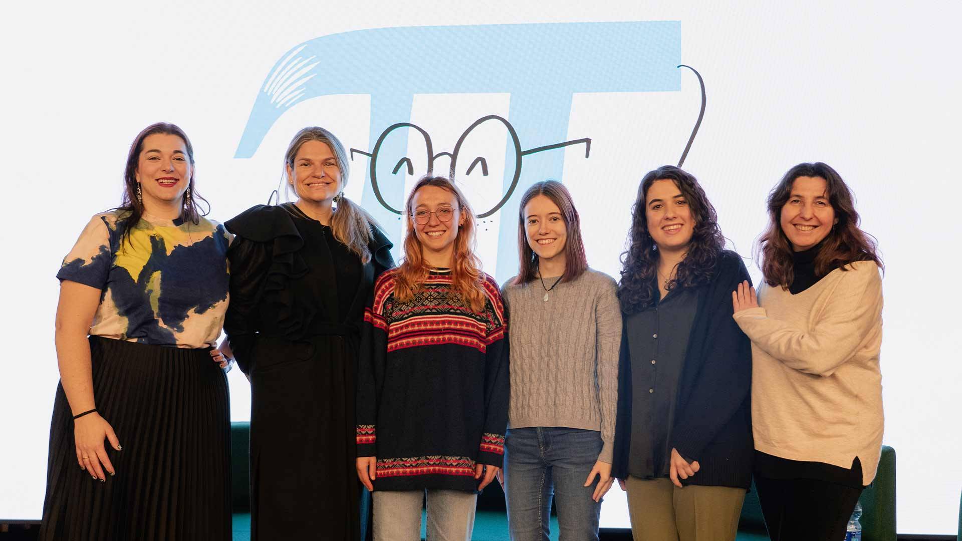Un grupo de seis mujeres posando juntas frente a un fondo con un diseño gráfico.