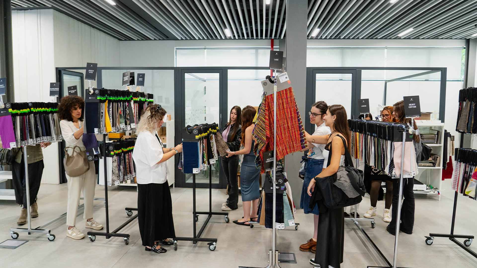 Un grupo de personas observa y elige productos en un evento de moda.