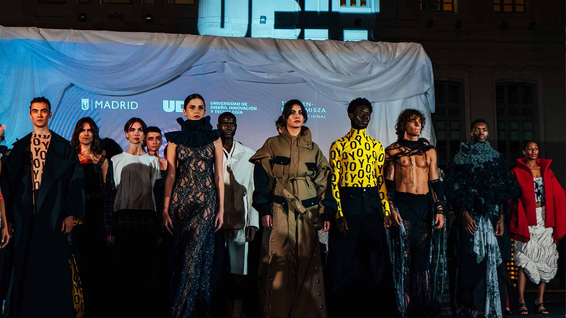 Desfile de moda con modelos mostrando prendas innovadoras y creativas en un evento nocturno.