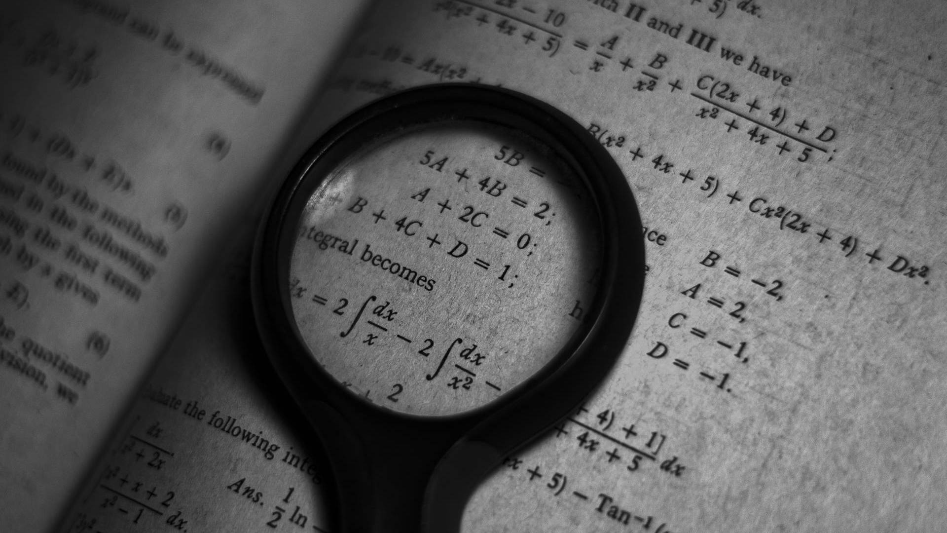 Una página de un libro de matemáticas con ecuaciones y un aumento a través de una lupa.