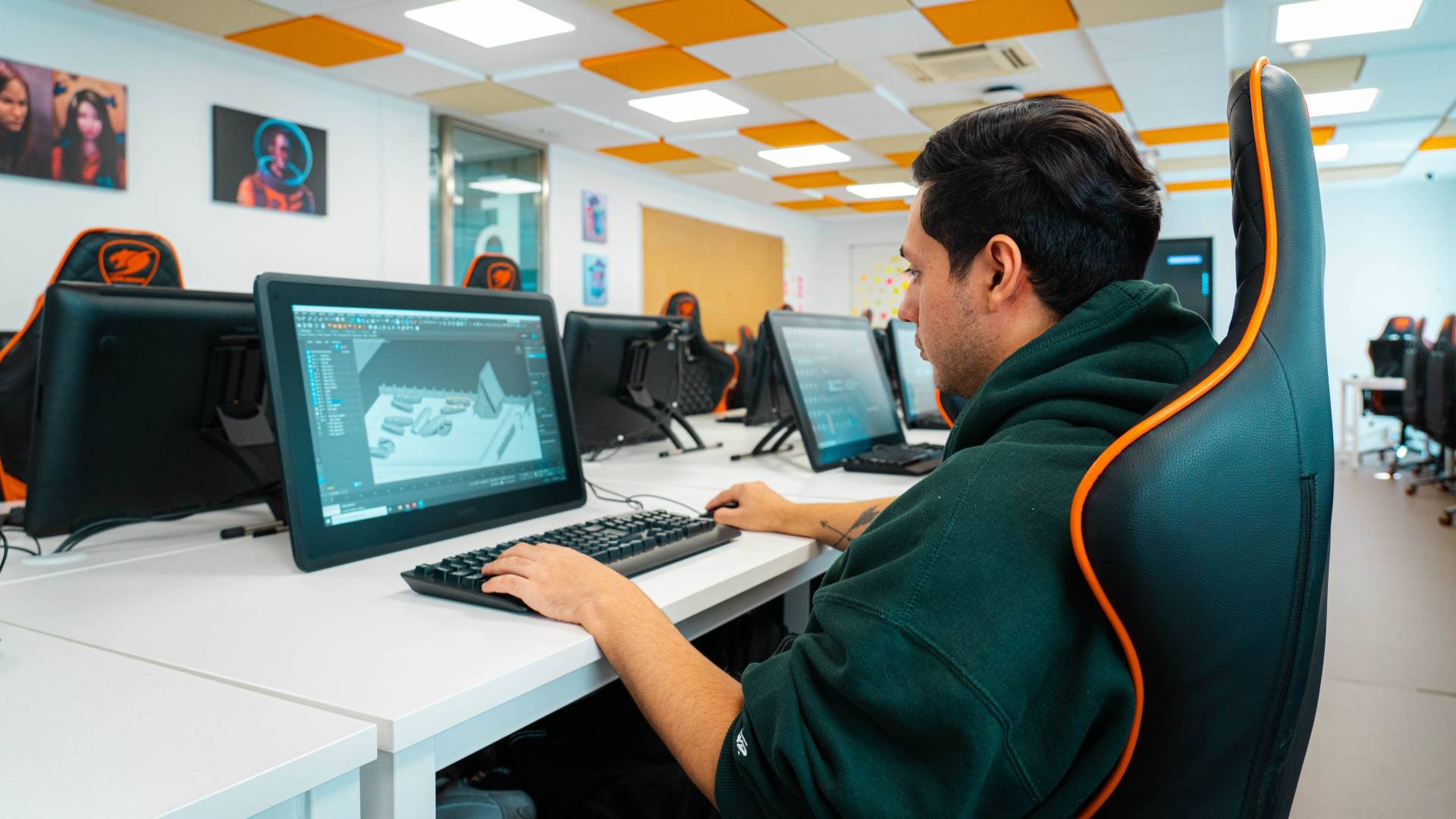 Un hombre trabaja en una computadora en un entorno de oficina moderna.