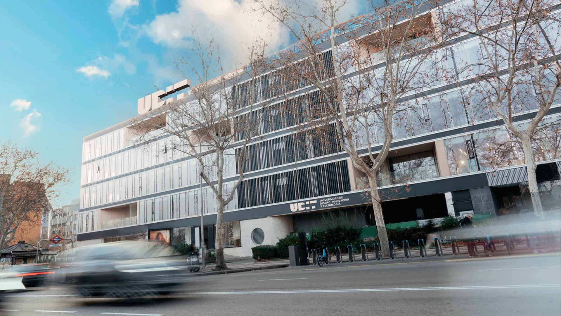 Edificio moderno con una fachada de cristal ubicado en una calle urbana.