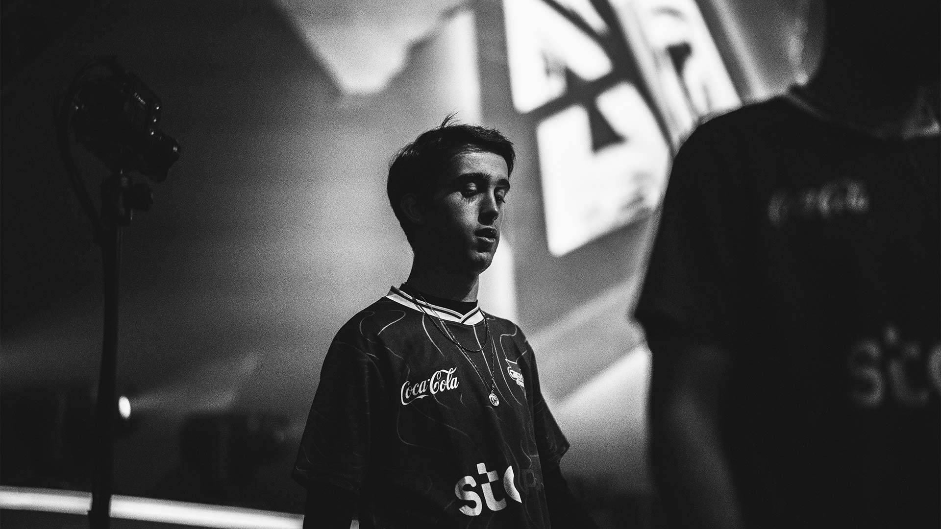 Un joven en un entorno de competición de eSports, luciendo una camiseta con logos de marcas conocidas.