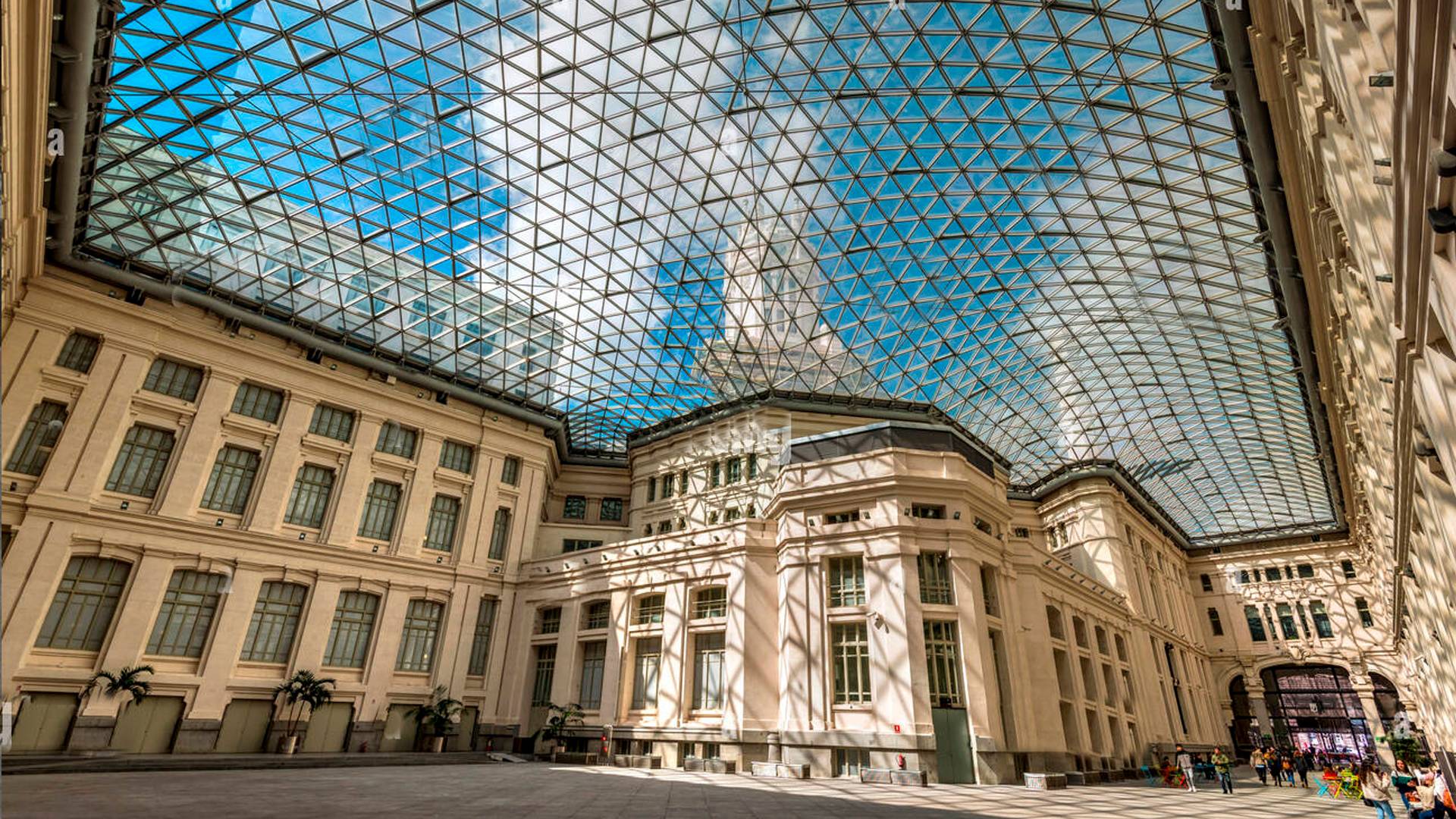 Una imponente edificación con un techo de cristal brillante que permite la entrada de luz natural.